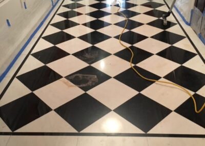 A black and white checkered floor in a hallway with some equipment's