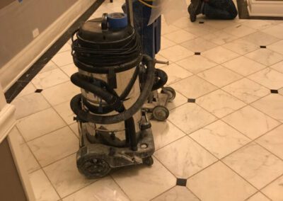 A boy sitting on the floor with a vacuum in front of him