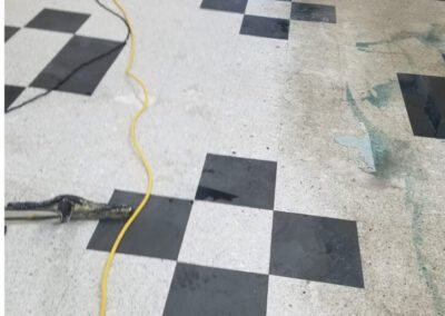 A black and white checkered floor with a yellow hose and other equipments aroud