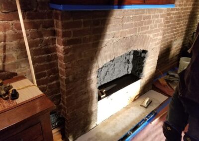 A brick fireplace being built in a living room