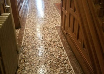 A hallway with a wooden door and a tiled floor